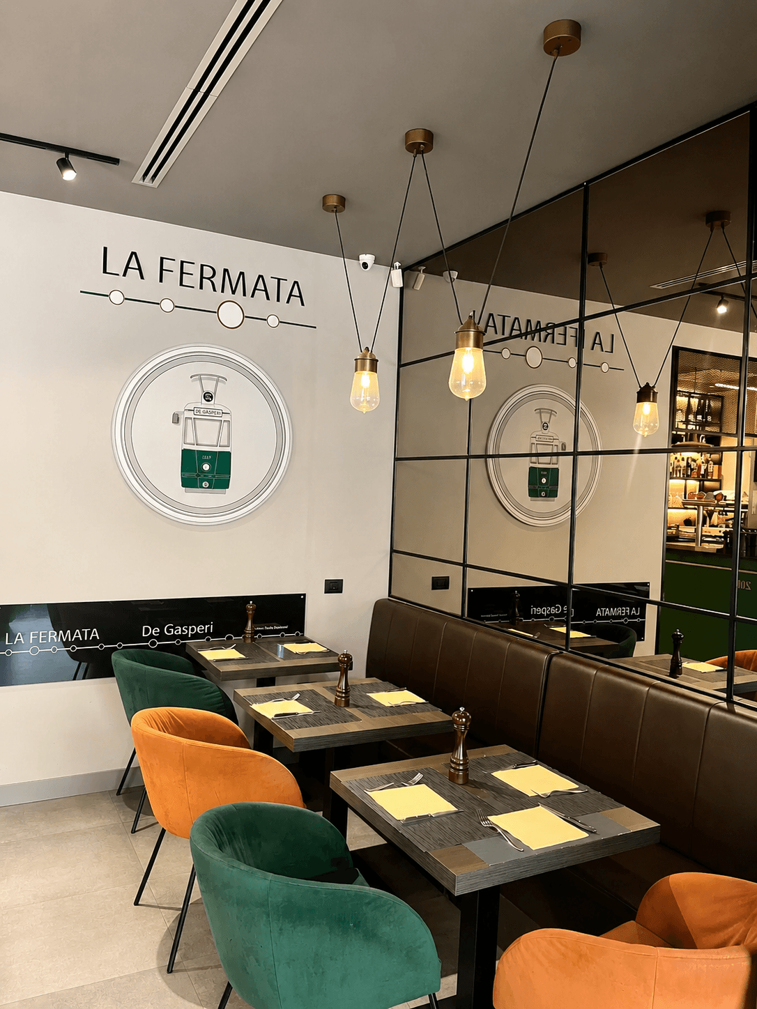 Interno de La Fermata con logo e tavoli